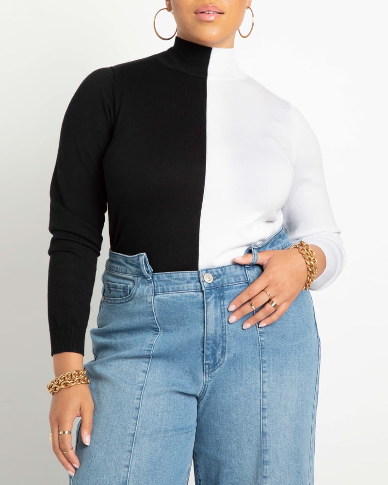 Front of a model wearing a size 14/16 Iris Vertical Colorblocked Turtleneck in Black And White by ELOQUII. | dia_product_style_image_id:242107
